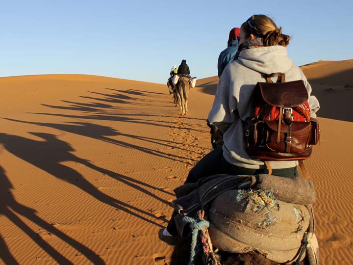 student riding camel in the Sahara Desert