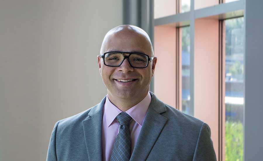 photo of Albert Orbinati, bald younger white man with glasses, wearing a business suit.