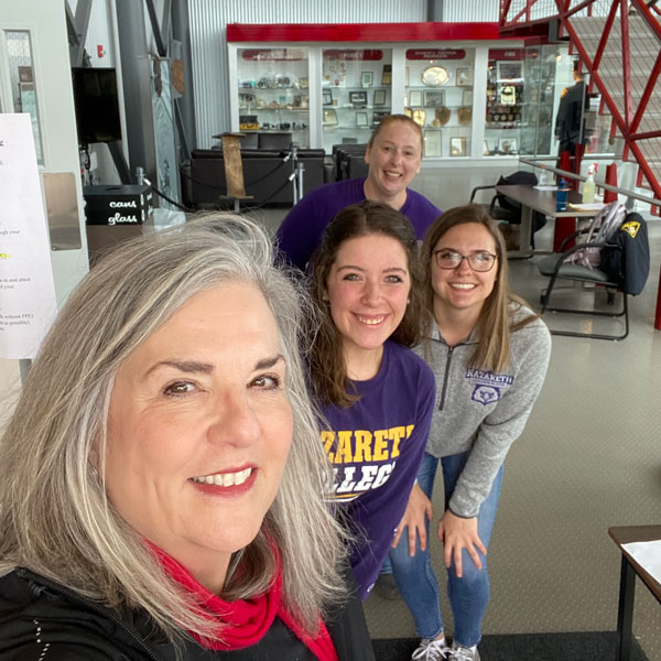 Three nursing students and nursing chair pose for a selfie at emergency response center