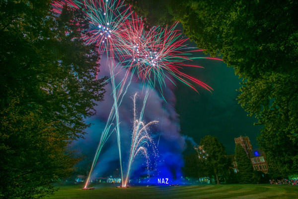 Multi-colored fireworks erupt by the NAZ letter and Smyth Hall