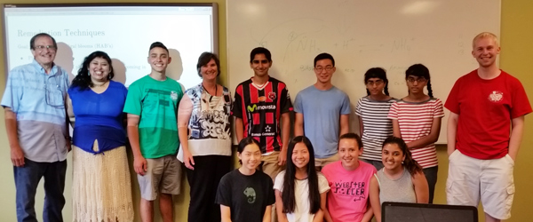 faculty, students, and children standing together in a classroom