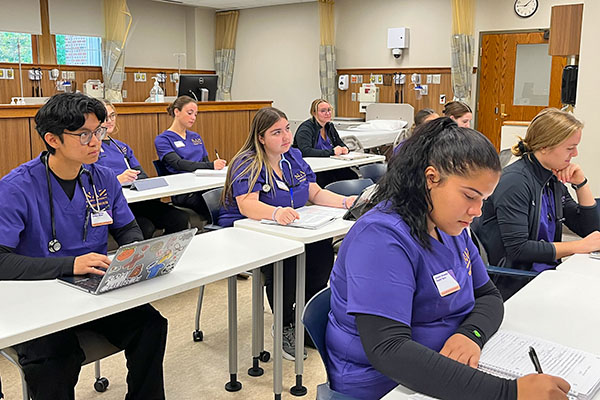 nursing students in the sim lab listening to a lecture