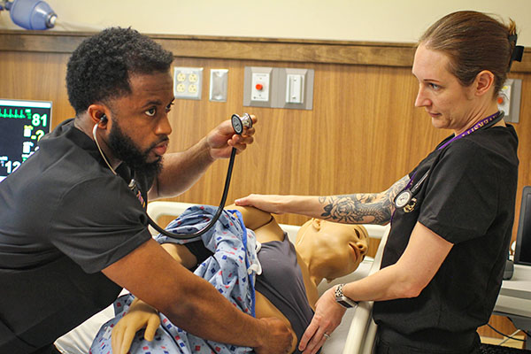 physician assistant student practicing with sim patient