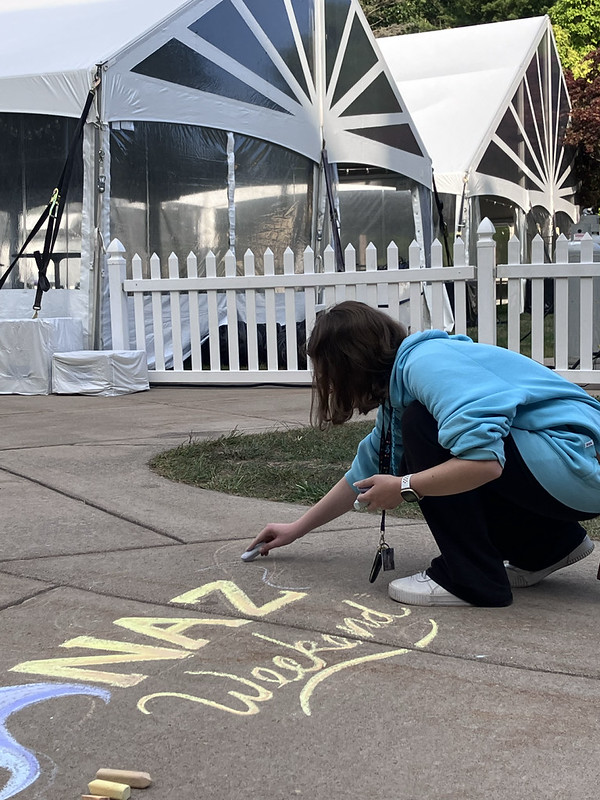 Student chalking "Naz Weekend"