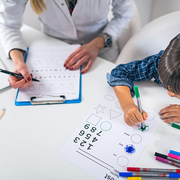 psychologist observing child taking a test