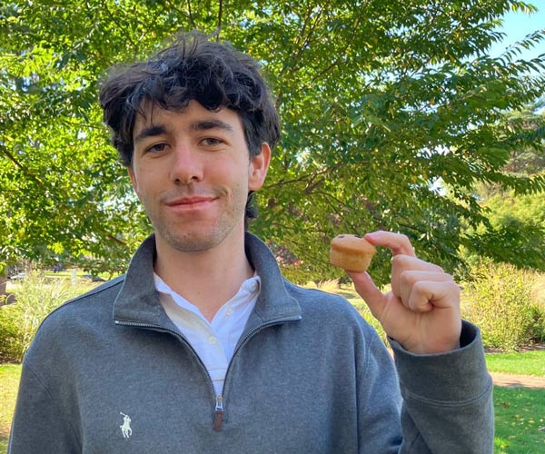 Joshua Powers holds an Abe's chocolate chip mini muffin