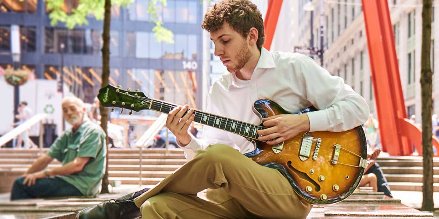student musician playing a guitar in New York City