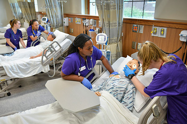 nursing students examining sim patients