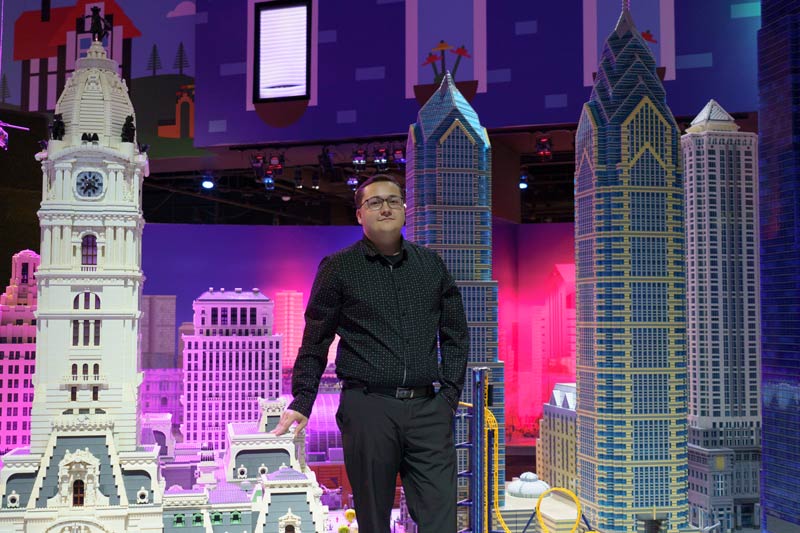 Trevor Adams is dwarfed by Philadelphia buildings recreated with LEGO bricks.